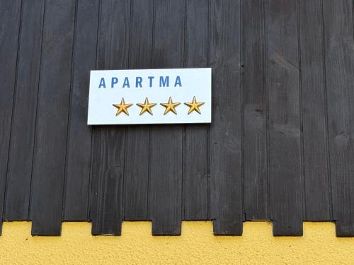 a sign on a fence with four gold stars at Apartma Devs in Kranjska Gora