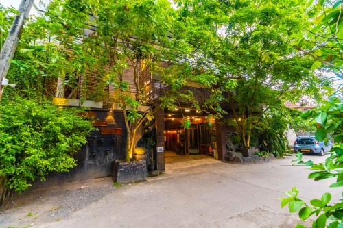 a building with trees in front of a street at Cinnamon Airport Residencies in Katunayaka