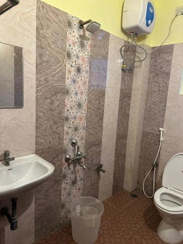 a bathroom with a shower and a toilet and a sink at Five stones By Earth Hotel Vadapalani in Chennai