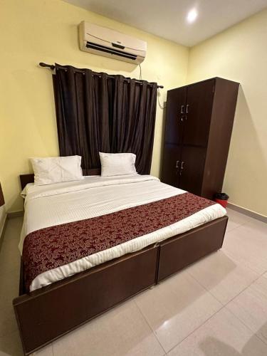 a bedroom with a large bed with a black curtain at Five stones By Earth Hotel Vadapalani in Chennai
