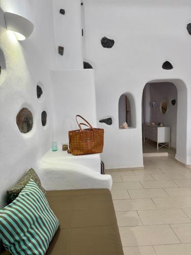 a white room with a bench with a purse on it at Manias Fira Residences in Fira