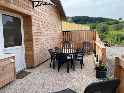 a patio with a table and chairs next to a building at Gîte Lucanna in Cenves