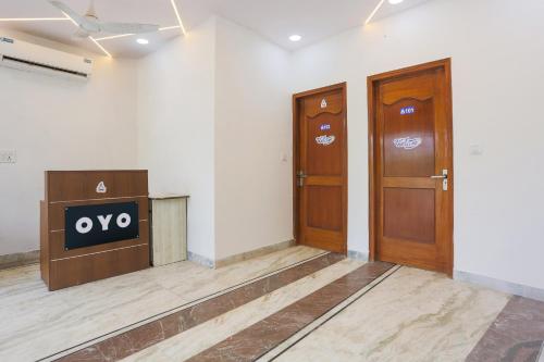 a lobby with two wooden doors and a podium at Hotel O Golden Key Rohini in New Delhi