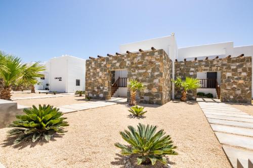 a courtyard of a building with palm trees at Cato Agro 4, Seafront Villa with Private Pool in Karpathos Town