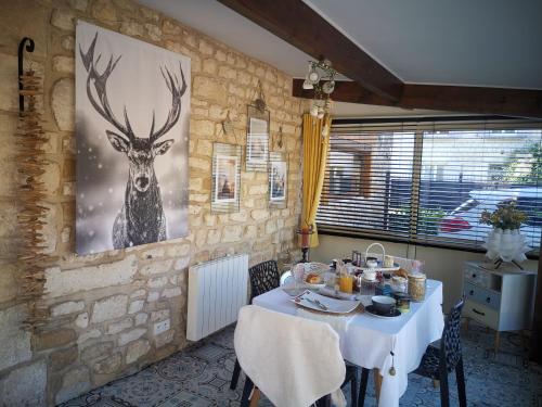 une salle à manger avec une table et une photo de cerf dans l'établissement Chambre d'hôtes de Marie, à Chémery