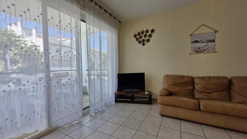 un salon avec un canapé et une télévision dans l'établissement Royan - APPARTEMENT avec EMPLACEMENT IDEAL - terrasse - garage privatif, à Royan