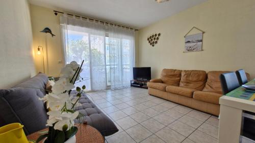 un salon avec un canapé et une télévision dans l'établissement Royan - APPARTEMENT avec EMPLACEMENT IDEAL - terrasse - garage privatif, à Royan