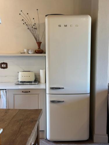 a white refrigerator in a kitchen next to a table at Nido di Gufi in Todi