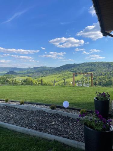 a view from the backyard of a house with a playground at Chata Rajski Widok in Baligród