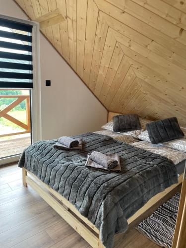 a large bed in a room with a wooden ceiling at Chata Rajski Widok in Baligród
