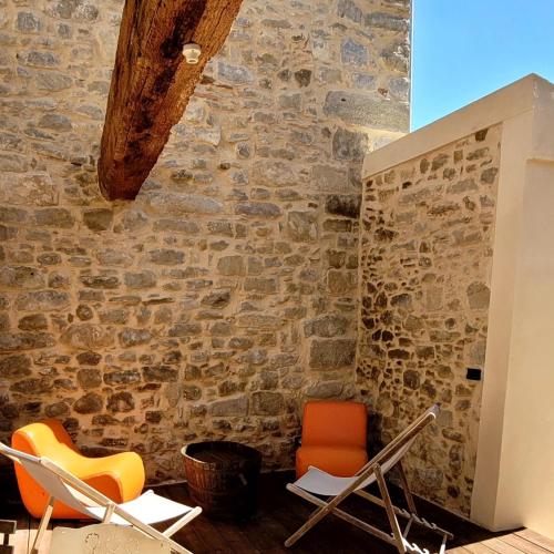 a room with chairs and a stone wall at Domaine du Prieuré Couvent & Presbytère in Carcassonne
