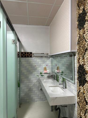 a bathroom with two sinks and a mirror at Mai Vien Homestay & restaurant in Cư Chinh