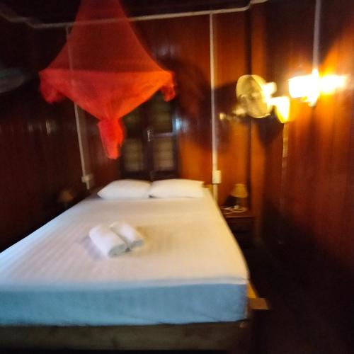 a bedroom with a bed with two towels on it at Nomad Guesthouse in Kratie