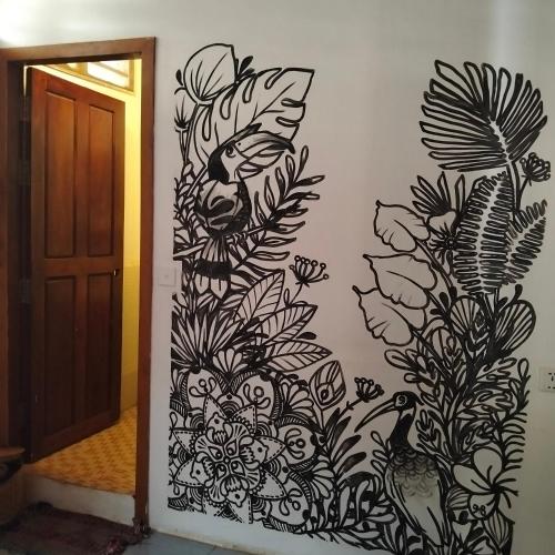 a wall with a painting of flowers on a wall at Nomad Guesthouse in Kratie