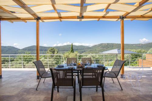 - une salle à manger avec une table et des chaises offrant une vue dans l'établissement Superb neo-Provençal villa with swimming pool air conditioning and view, à Bagnols-en-Forêt