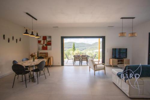 un salon avec un canapé, une table et des chaises dans l'établissement Superb neo-Provençal villa with swimming pool air conditioning and view, à Bagnols-en-Forêt