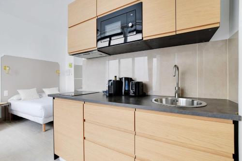 a kitchen with a sink and a microwave at Studio Moderne - AC- 4P- Champ-de-Mars in Paris