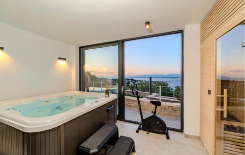 a bathroom with a jacuzzi tub and large windows at Lovely Home In Preko With Sauna in Preko