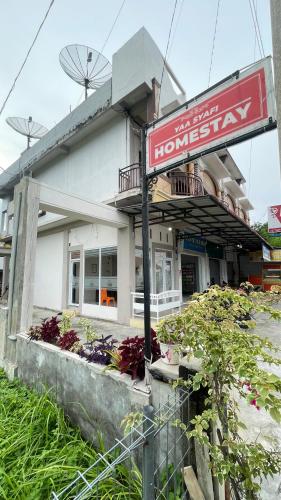a building with a sign in front of it at Homestay Yaa Syafi in Bireun