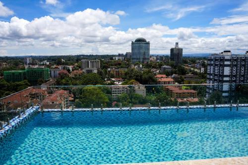 a large swimming pool with a city in the background at Rooftop pool, gym and stunning city views in Nairobi