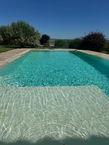 une grande piscine avec de l'eau bleue dans l'établissement Maison avec terrasse proche Grignan, à Colonzelle