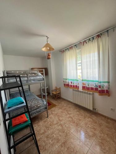 a room with two bunk beds and a window at Pirineo Aragonés. Casa La Paz in Sabiñánigo