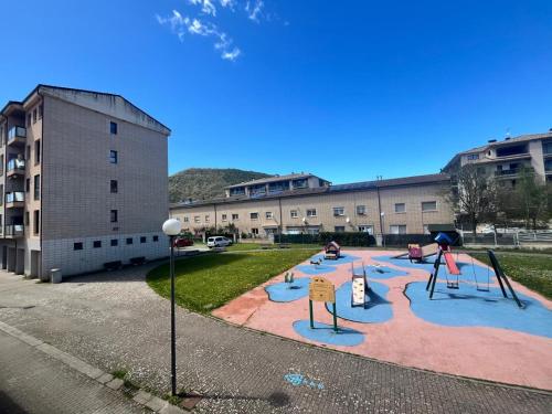 a playground in front of a large building at Pirineo Aragonés. Casa La Paz in Sabiñánigo