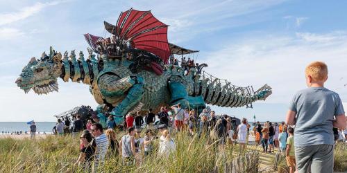a group of people standing in front of a dragon float at Le Bleu d'Opale in Sangatte
