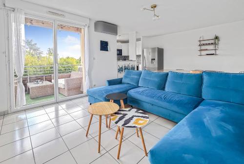 un salon avec un canapé bleu et une table dans l'établissement Appartement Lumineux Avec Balcon et piscine, à Les Billaux