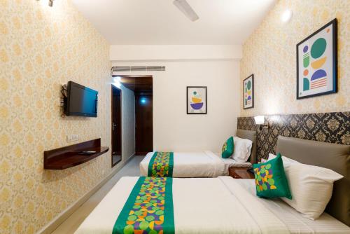 a hotel room with two beds and a flat screen tv at Treebo Seasons - Heritage Town Pondicherry in Puducherry