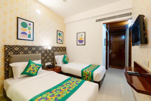 a hotel room with two beds and a television at Treebo Seasons - Heritage Town Pondicherry in Puducherry