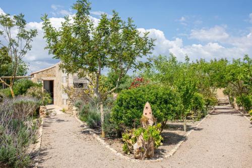 a garden with trees and bushes in front of a building at Agroturisme Es Racó De Maria in Maria de la Salut