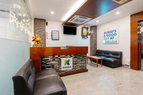 a waiting room with a couch and a tv at Treebo Seasons - Heritage Town Pondicherry in Puducherry