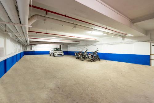 a garage with motorcycles and a car parked in it at Treebo Seasons - Heritage Town Pondicherry in Puducherry