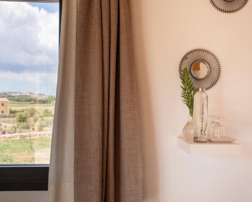 a window with a curtain and a mirror on a shelf at Agroturisme Es Racó De Maria in Maria de la Salut