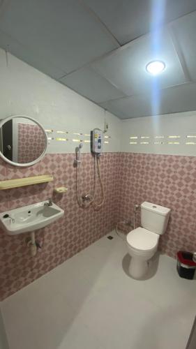 a bathroom with a toilet and a sink and a mirror at ชมดอยรีสอร์ท in Chiang Dao