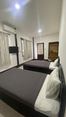 two beds in a room with two windows at ชมดอยรีสอร์ท in Chiang Dao