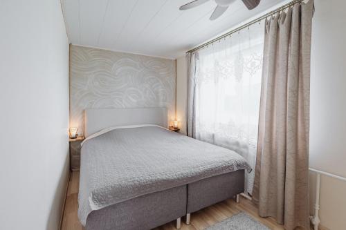 a small bedroom with a bed and a window at Kuuse 4 Apartment with 2 bedrooms in Haapsalu