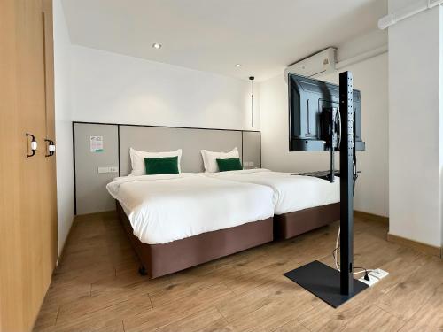 a bedroom with a large bed and a television at Pentafield City Residence in Amphoe Phra Khanong