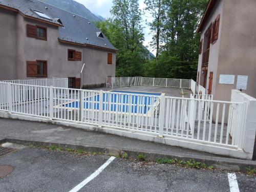 a white fence in front of a building at Les Estives de Cauterêts in Cauterets