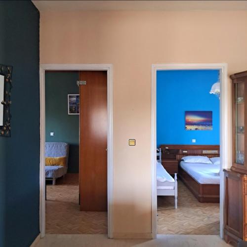 a room with two beds and a door to a bedroom at Compass in Kavála