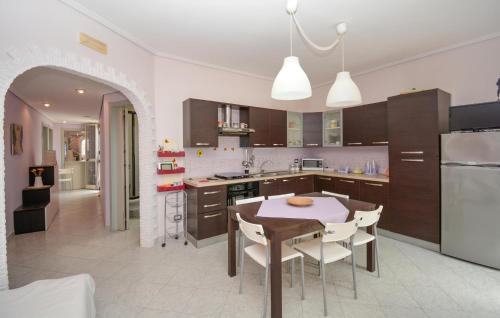 a kitchen with a table and chairs in a kitchen at Cozy Apartment In Santa Croce Camerina in Santa Croce Camerina