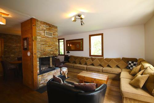 un salon avec un canapé et une cheminée dans l'établissement Ski-in/Ski-out Chalet, Quiet Location, and Jacuzzi, à Vars