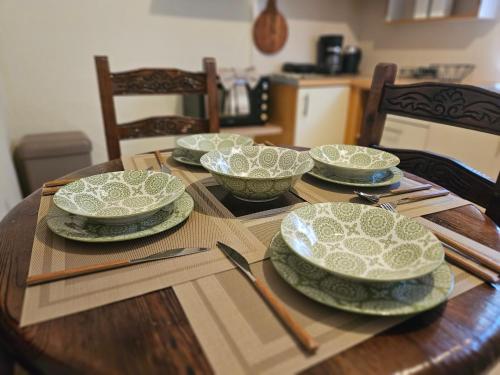 a wooden table with four plates and bowls on it at Fiori Sea View Apartment in Pyrgi