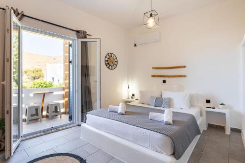 a bedroom with a large bed and a balcony at THIRAMNA Apts KYTHNOS in Mérikhas