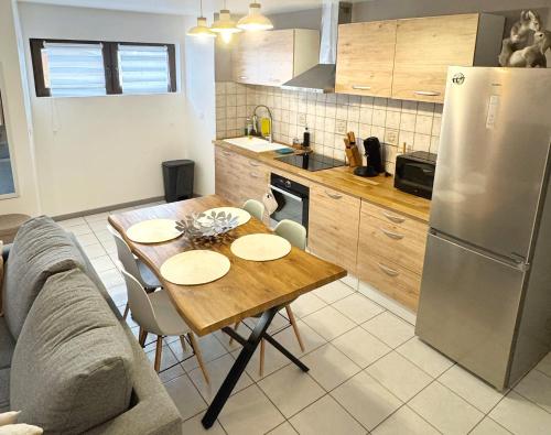 Una cocina con una mesa y un refrigerador de acero inoxidable. en CityLife, en Millau