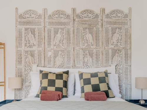 a bedroom with a white bed with two pillows at Rose Garden Maisonette in Falmouth