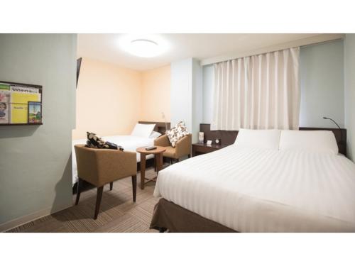 a hotel room with a bed and a table and chairs at Smile Hotel Kumamoto Suizenji - Vacation STAY 73106v in Kumamoto