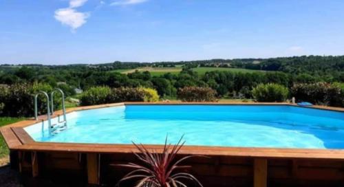 une grande piscine avec vue sur la campagne dans l'établissement Cottage Lavandes et Cottages Roses, à Crédin