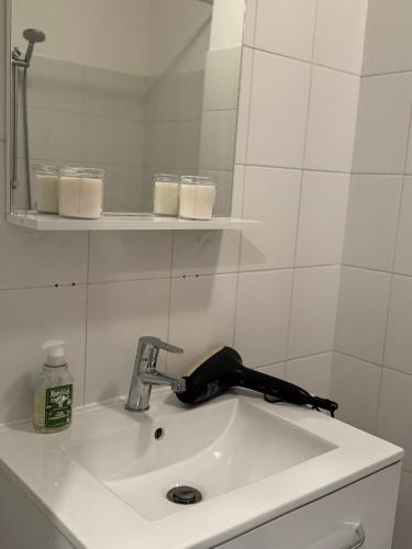 un lavabo de salle de bain avec un robinet et un miroir dans l'établissement Bel appartement au calme hyper centre Nice, à Nice